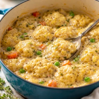 A hearty bowl of Creamy Chicken and Dumplings topped with fluffy dumplings in creamy broth.