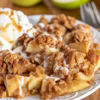 Warm Apple Cinnamon Crumble served with a scoop of vanilla ice cream.
