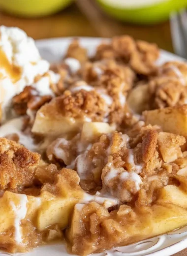 Warm Apple Cinnamon Crumble served with a scoop of vanilla ice cream.