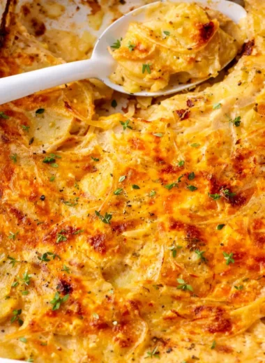 Delicious scalloped potatoes layered in creamy cheese sauce, perfect holiday side dish.
