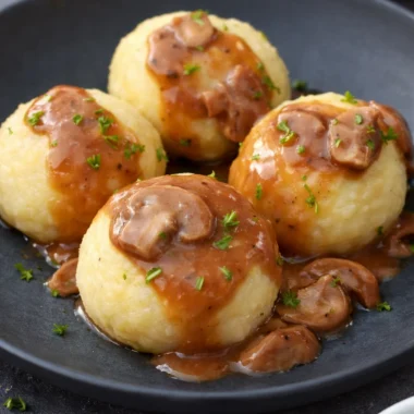 Traditional German Kartoffelklöße potato dumplings served with gravy.