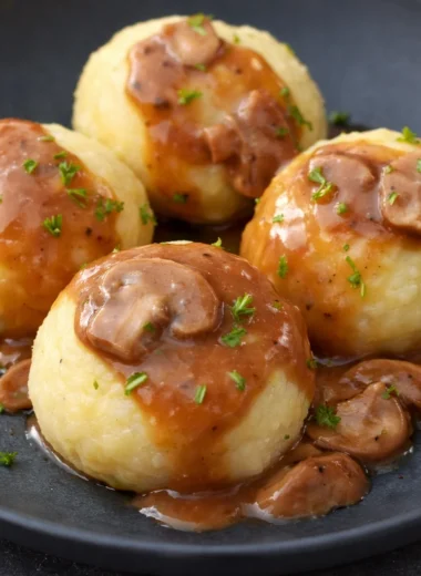 Traditional German Kartoffelklöße potato dumplings served with gravy.