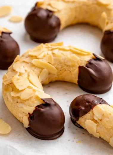 Traditional German Almond Horns (Mandelhörnchen) cookies dipped in chocolate.