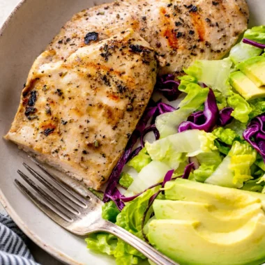 Grilled thin chicken breast cutlets cooked to perfection on a BBQ grill.