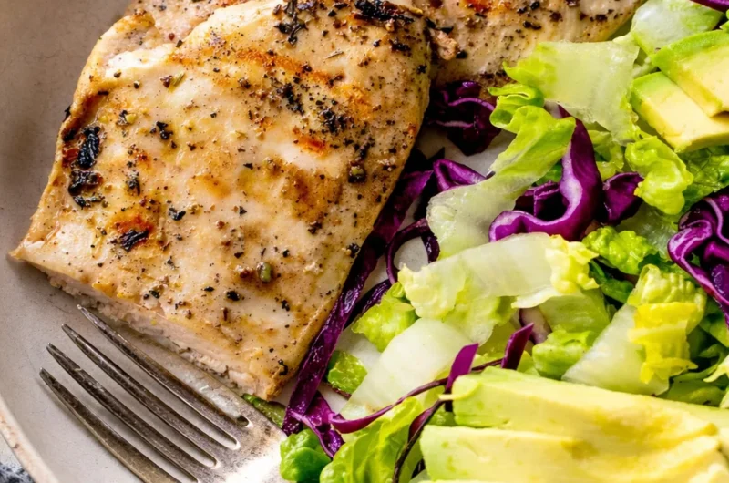 Grilled thin chicken breast cutlets cooked to perfection on a BBQ grill.