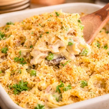 Delicious Tuna Noodle Casserole with pasta, tuna, peas, and cheesy topping.