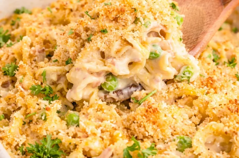 Delicious Tuna Noodle Casserole with pasta, tuna, peas, and cheesy topping.