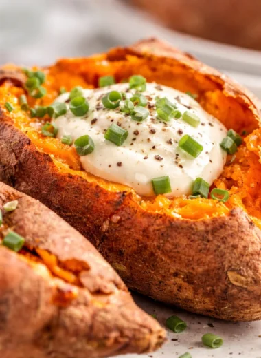 Baked sweet potatoes with crispy skins served on a plate.