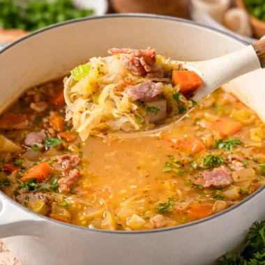 Hearty German Sauerkraut Soup (Sauerkrautsuppe) served in a bowl with crusty bread.