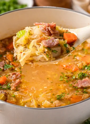Hearty German Sauerkraut Soup (Sauerkrautsuppe) served in a bowl with crusty bread.