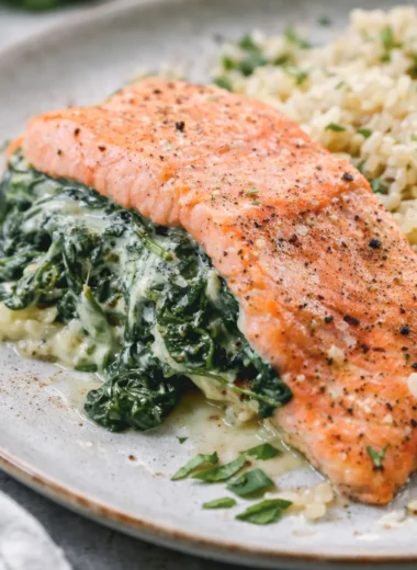Baked Salmon with Spinach and Mozzarella served on a plate, garnished with herbs.