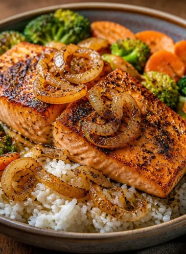 Crispy salmon rice bowl garnished with garlic pepper and vegetables