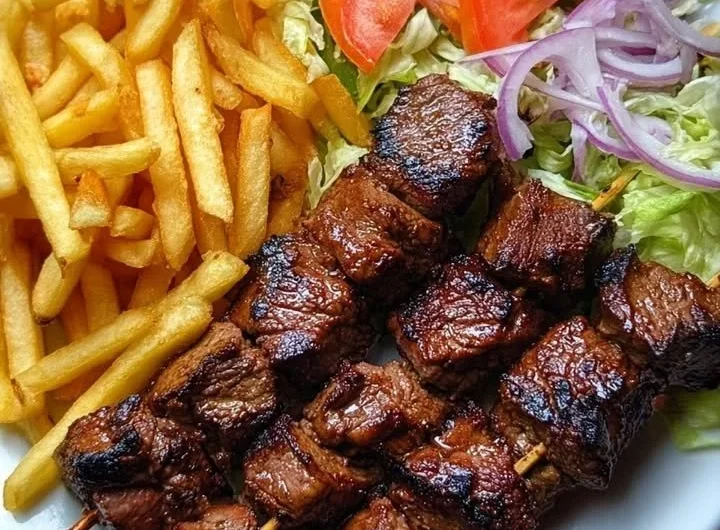 Crispy beef skewers served with fries and a garden salad