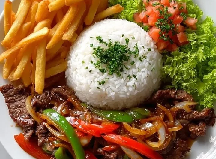 Crispy beef stir-fry with rice, fries, and colorful salad on a plate.
