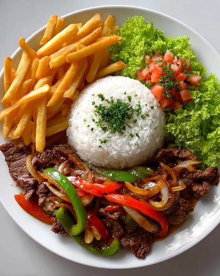 Crispy beef stir-fry with rice, fries, and colorful salad on a plate.