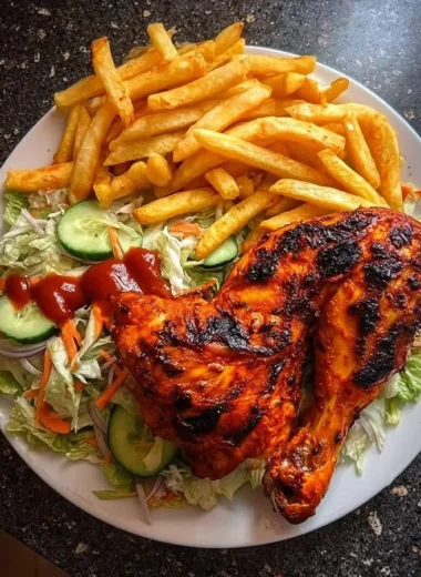 Flame-grilled chicken leg quarters with fries and salad on a plate