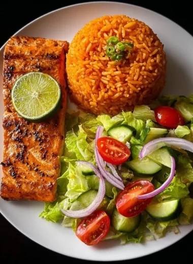 Lime-glazed salmon served with Spanish rice and a fresh garden salad.