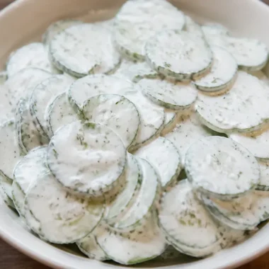 Creamy cucumber salad served in a bowl with fresh herbs