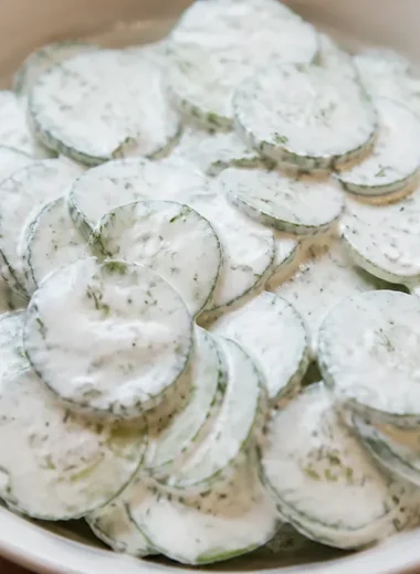 Creamy cucumber salad served in a bowl with fresh herbs