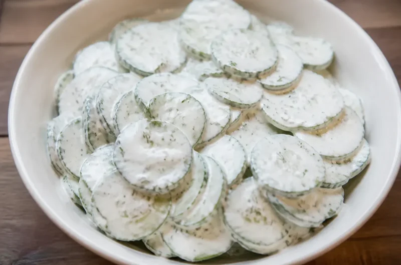 Creamy cucumber salad served in a bowl with fresh herbs