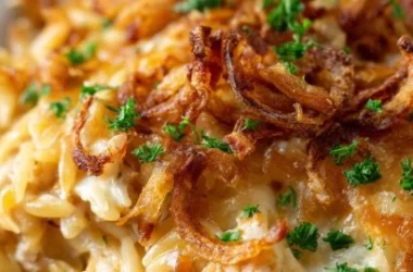 Creamy French onion chicken orzo casserole garnished with herbs and cheese