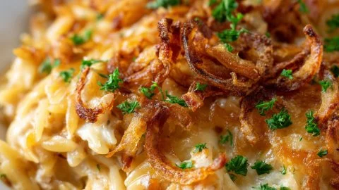Creamy French onion chicken orzo casserole garnished with herbs and cheese