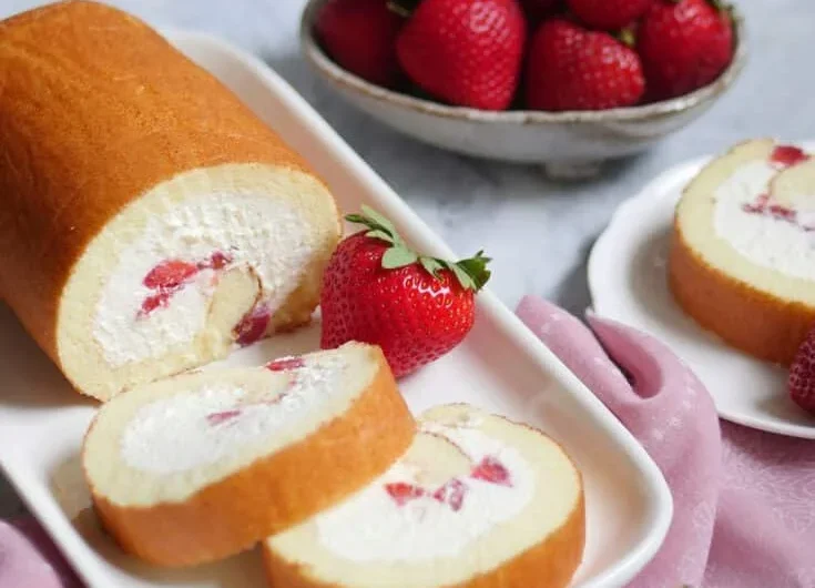 Creamy strawberry Japanese cake roll with fresh strawberries and whipped cream filling