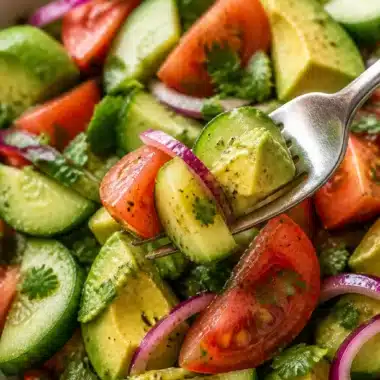 Gurken-Tomaten-Avocado-Salat in einer bunten Schüssel