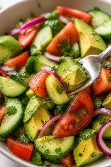 Gurken-Tomaten-Avocado-Salat in einer bunten Schüssel