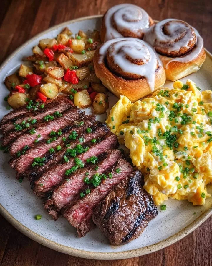 Steak Breakfast Plate with Scrambled Eggs & Cinnamon Rolls 33 Steak Breakfast Plate with scrambled eggs and cinnamon rolls served on a plate