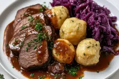 Traditional Sauerbraten dish served with gravy and side vegetables