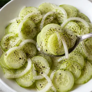 Einfaches Rezept für Gurkensalat mit Essig (mit süßer Zwiebel) 38 Gurkensalat mit Essig und süßer Zwiebel auf einem Teller
