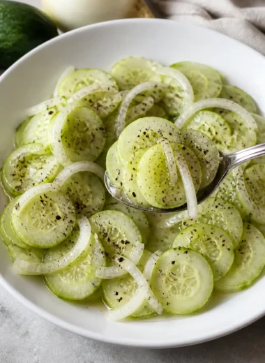Gurkensalat mit Essig und süßer Zwiebel auf einem Teller